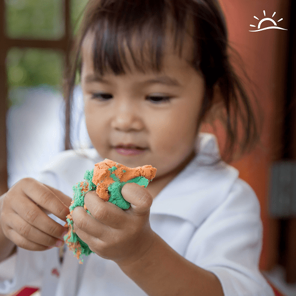 Toddler girl playing with clay